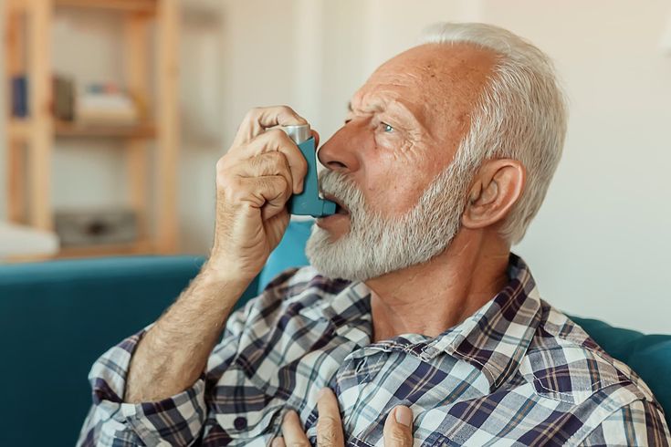 Older man using an inhaler for COPD at home